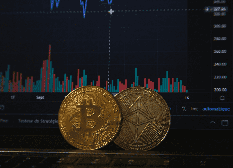 عملتا بيتكوين (Bitcoin) وإيثيريوم (Ethereum-ETH) تستندان إلى شاشة حاسوب محمول وتعرض مخططاً بيانياً