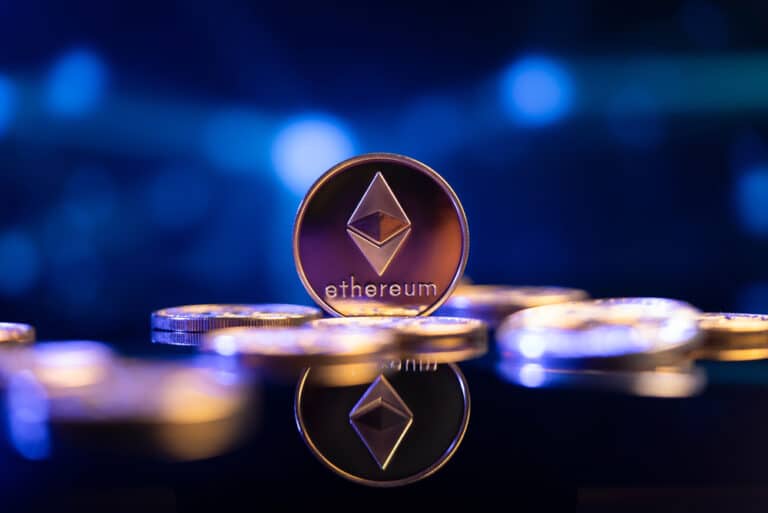 مجسم فضي لعملة إيثيريوم (Ethereum) على سطح لامع