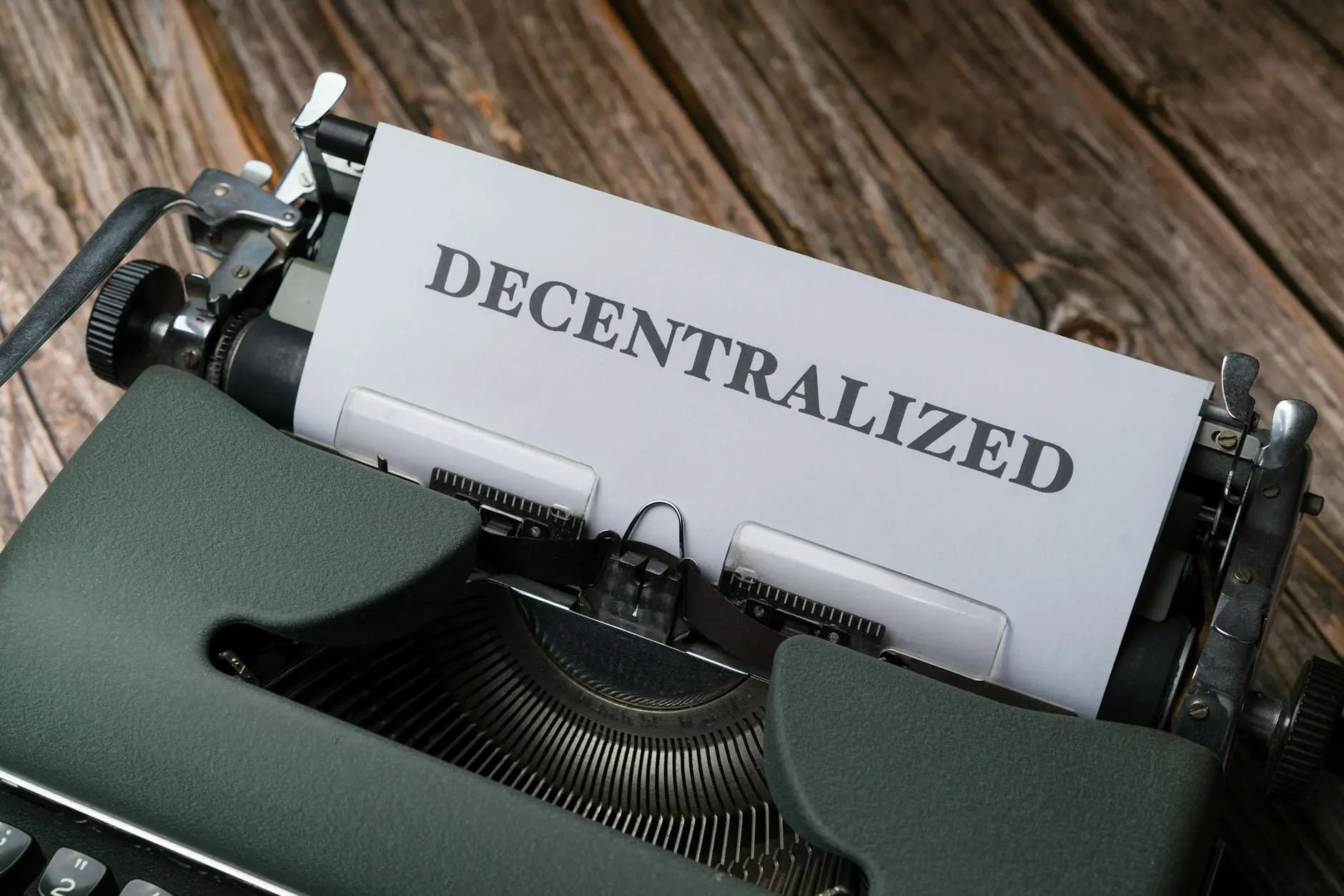 A typewriter with a sheet of paper showing the word 'DECENTRALIZED'.