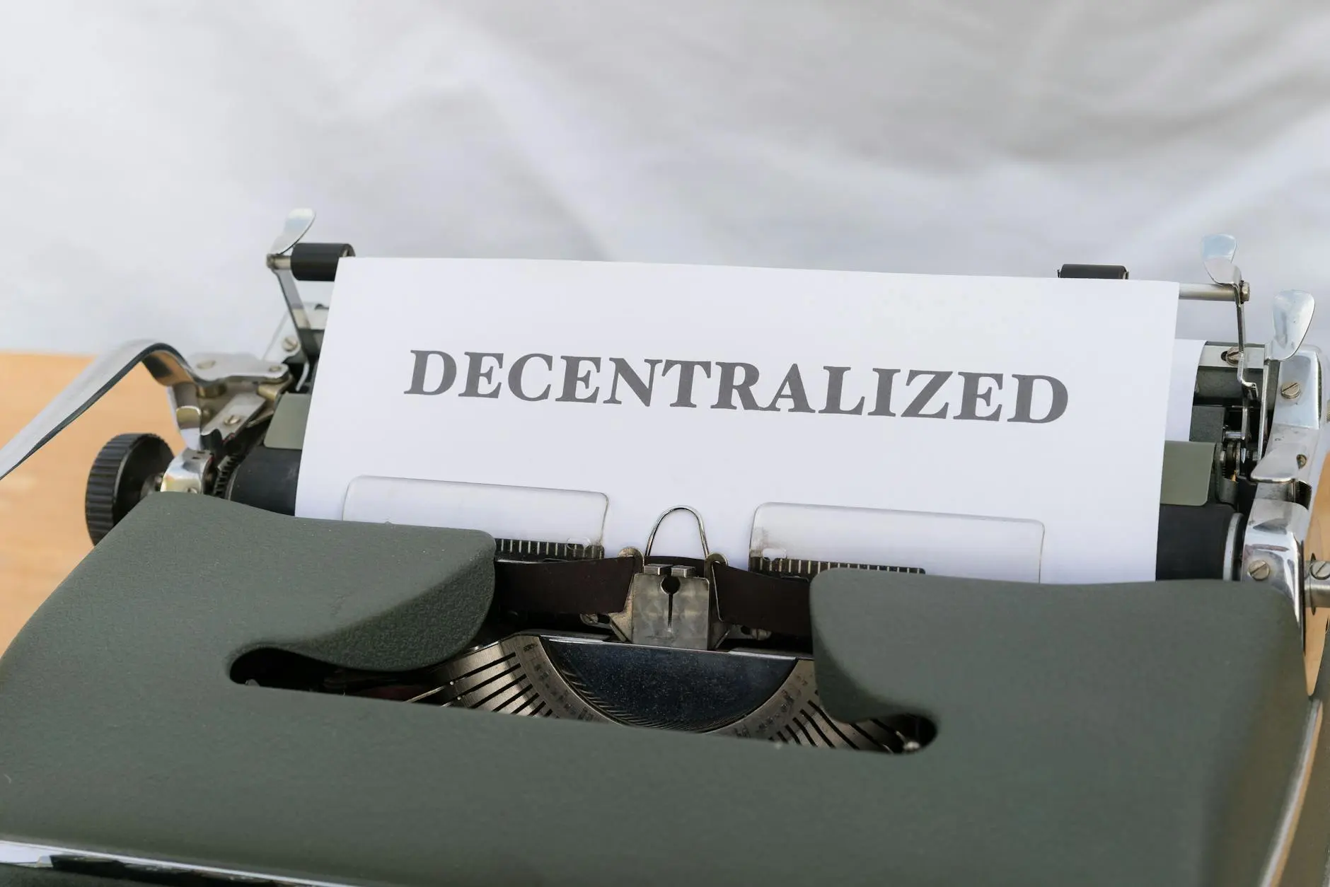 A typewriter with a paper showing the word 'DECENTRALIZED' prominently displayed.