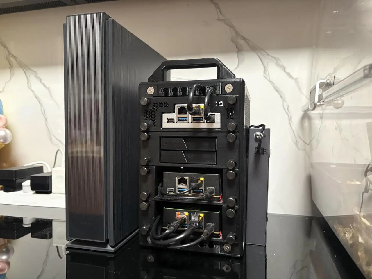 A stack of three small single-board computers inside a custom 3D-printed black chassis with a handle