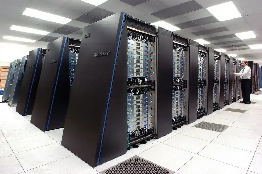 Rows of IBM Blue Gene/P supercomputer racks in a white tiled datacenter server room