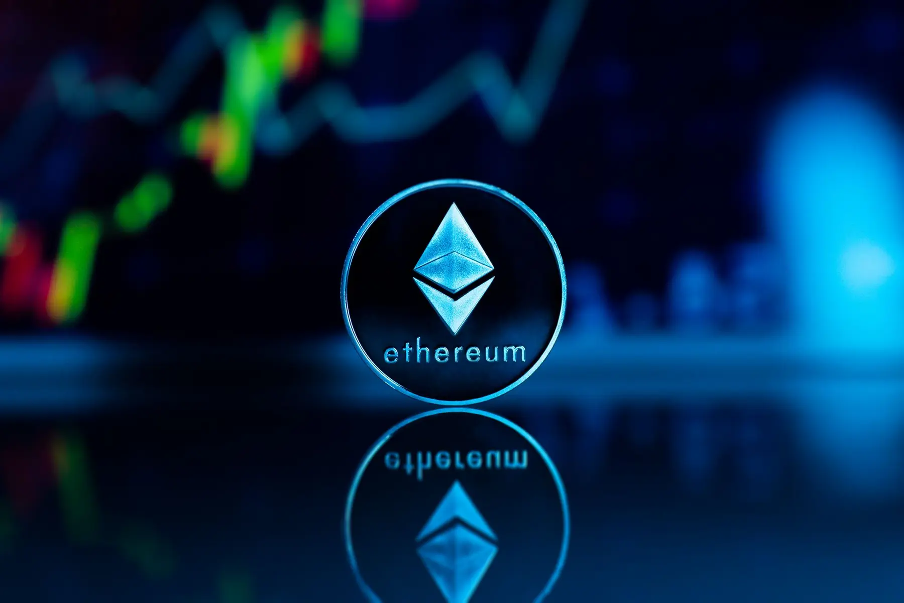 Close-up of a physical Ethereum coin reflecting on a dark surface with a digital trading chart in the background