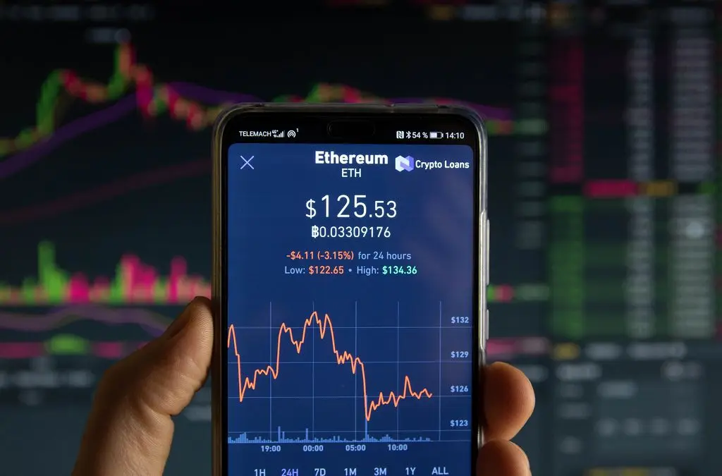 Smartphone displaying an Ethereum price chart with a value of $125.53 against a blurred trading background