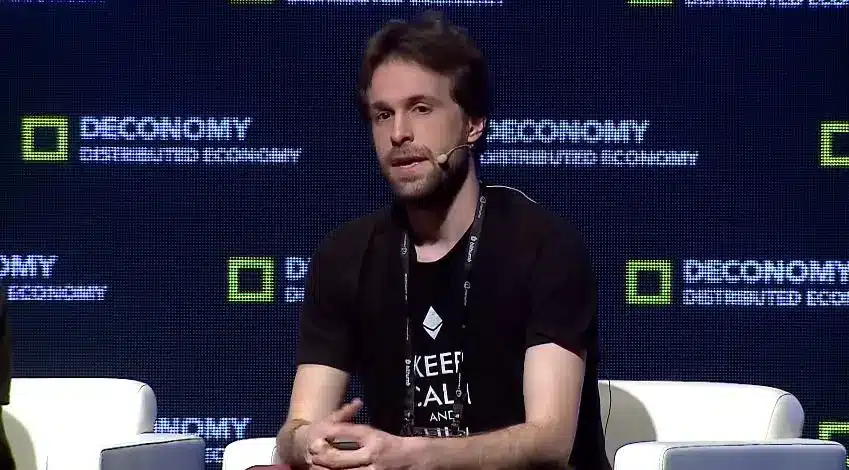 Justin Drake speaking at a Deconomy event while wearing an Ethereum logo t-shirt
