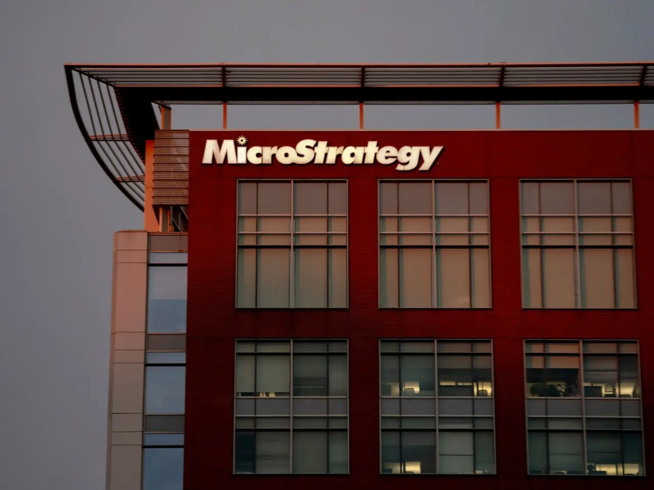 Exterior view of a red MicroStrategy headquarters building with company logo on the facade