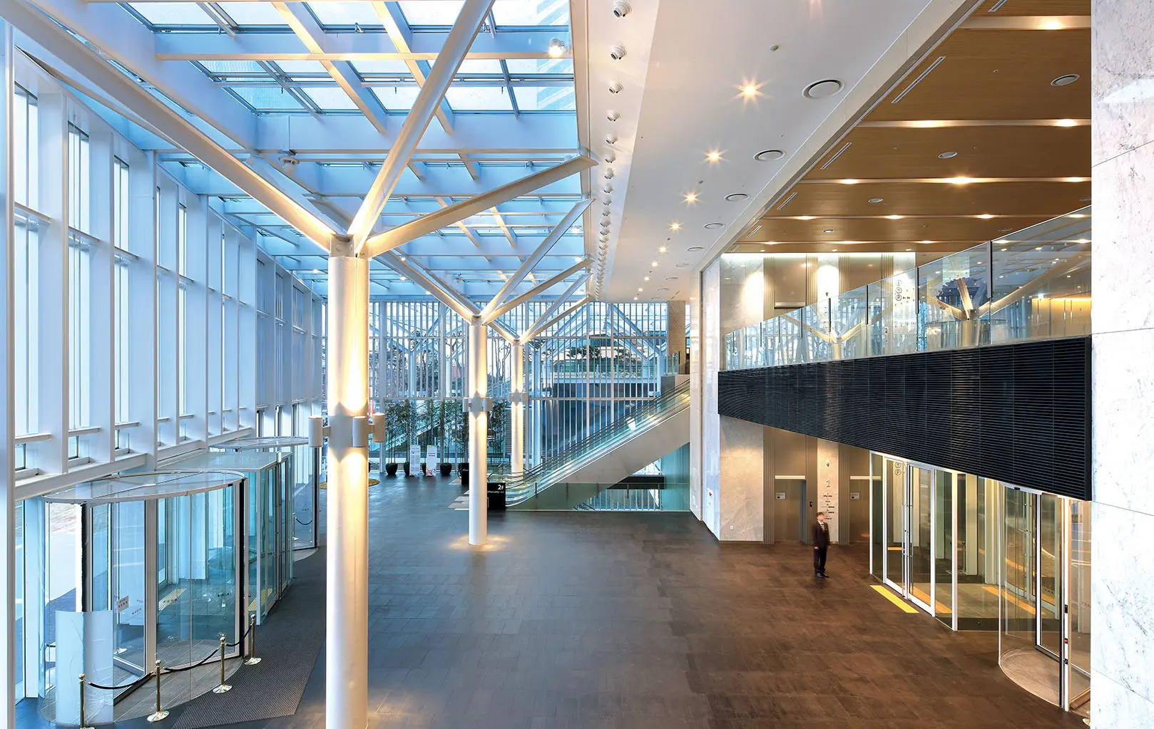 Interior view of the modern lobby at Mirae Asset Center 1 in Seoul, featuring high ceilings and a glass roof