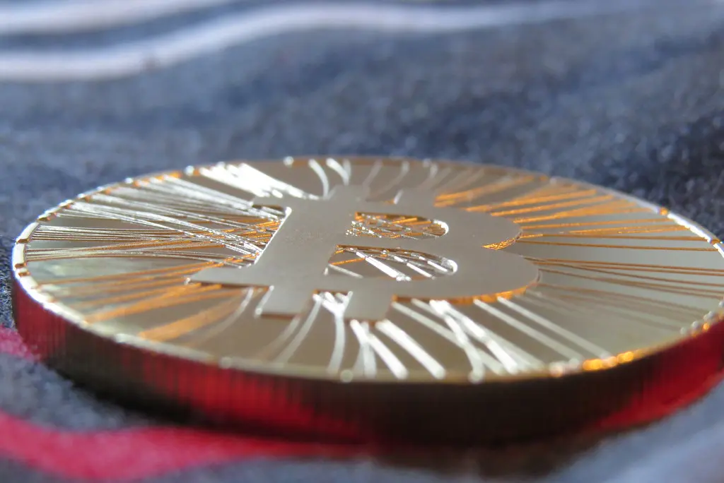 Eine goldfarbene physische Bitcoin-Münze mit dem markanten B-Symbol in einer Nahaufnahme.