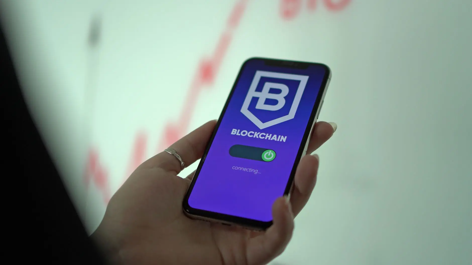 A hand holding a smartphone displaying the Blockchain crypto wallet app loading screen