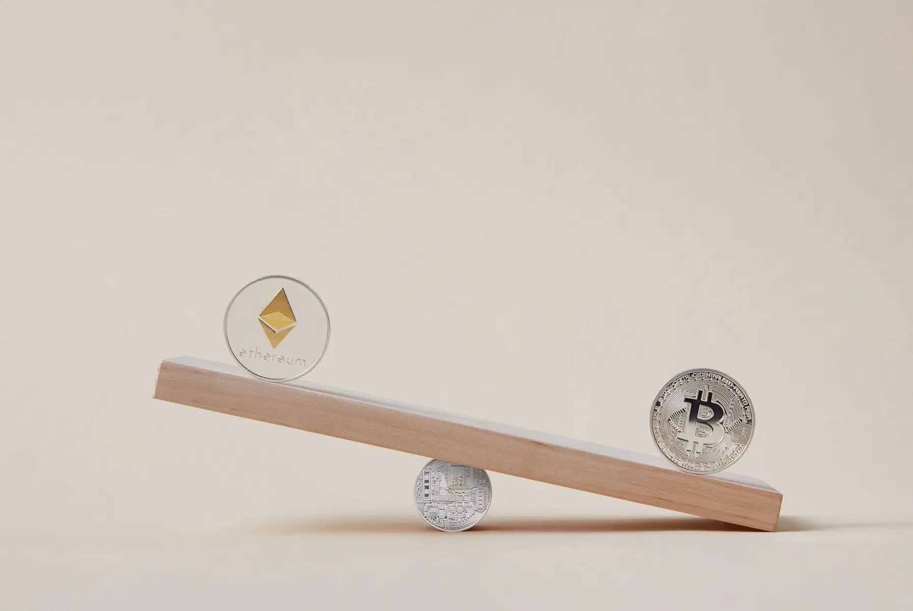 An Ethereum coin and a Bitcoin coin balancing on a wooden plank supported by a Litecoin coin