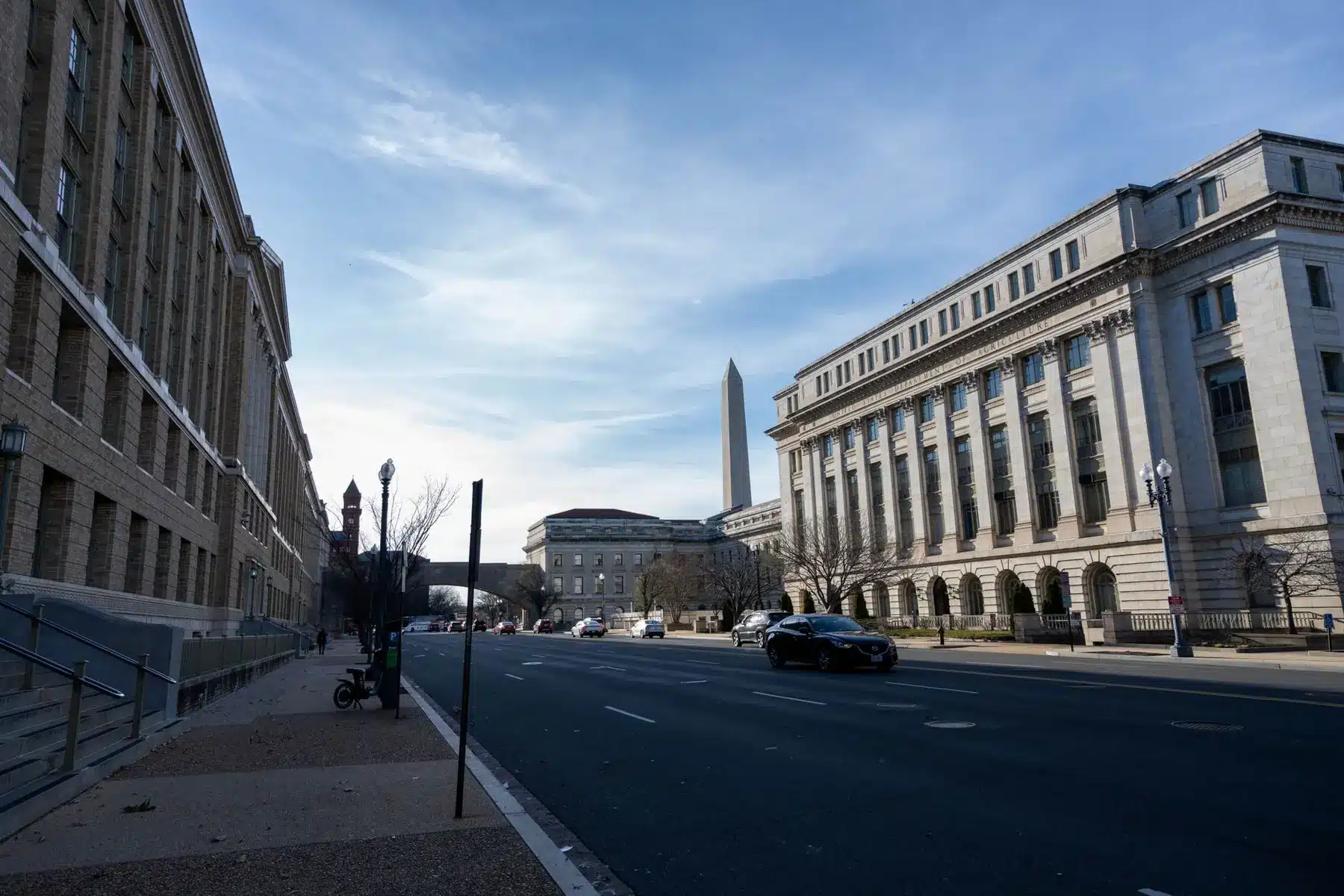 Exterior view of the Federal Reserve Eccles Building in Washington D.C. with the Washington Monument in the distance