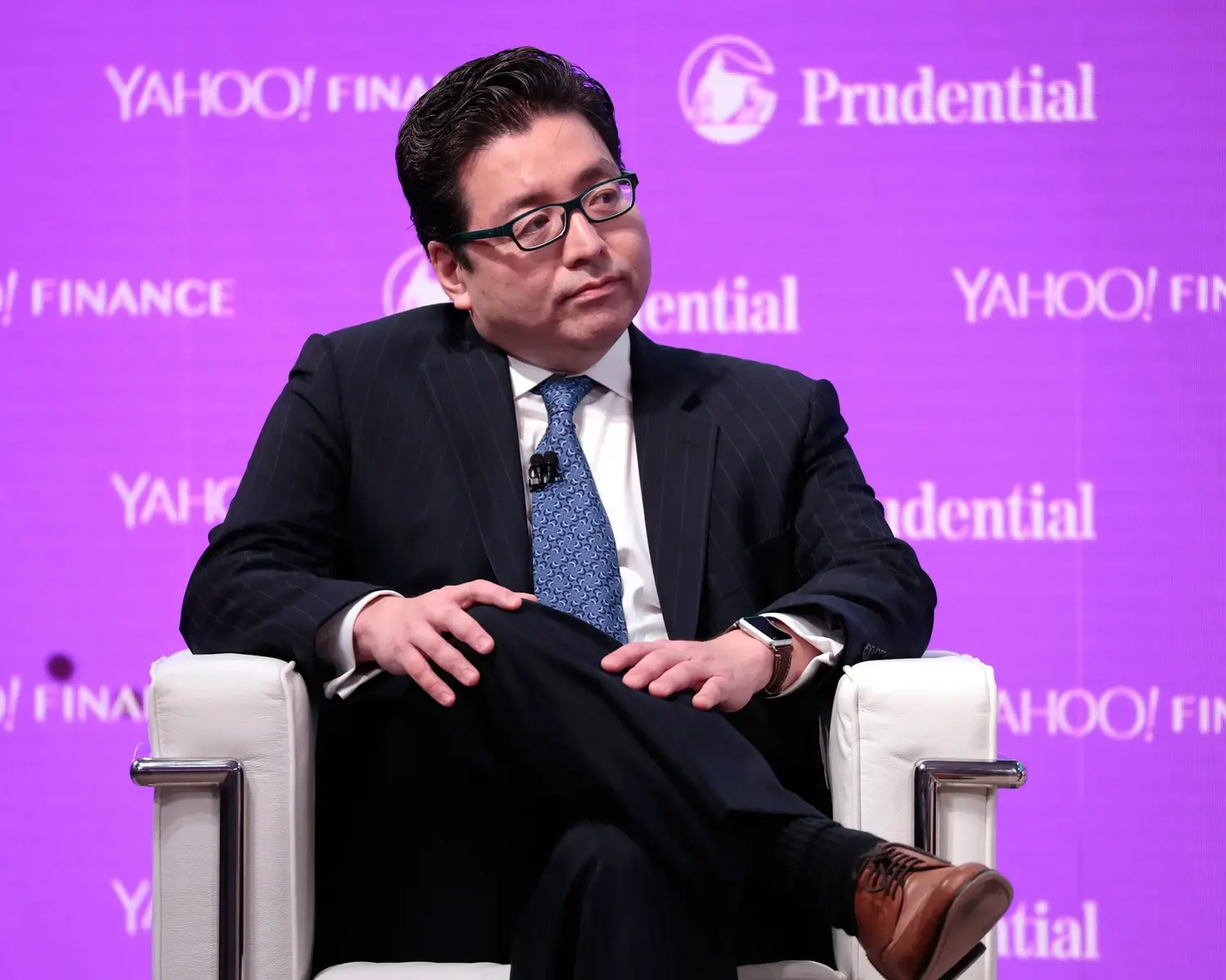 Tom Lee wearing a dark suit and glasses, seated against a purple backdrop with Yahoo Finance and Prudential logos.