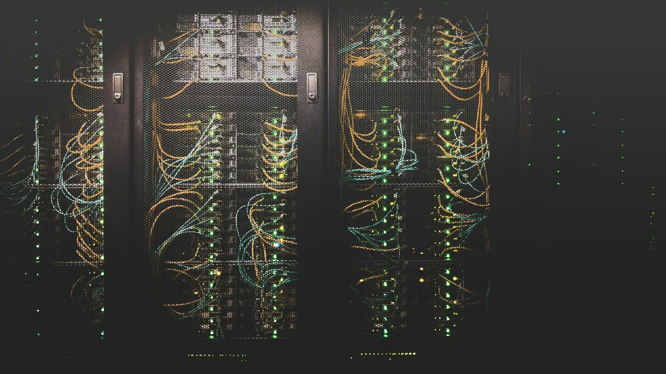 Server-Racks in einem Rechenzentrum mit zahlreichen bunten Netzwerkverkabelungen.