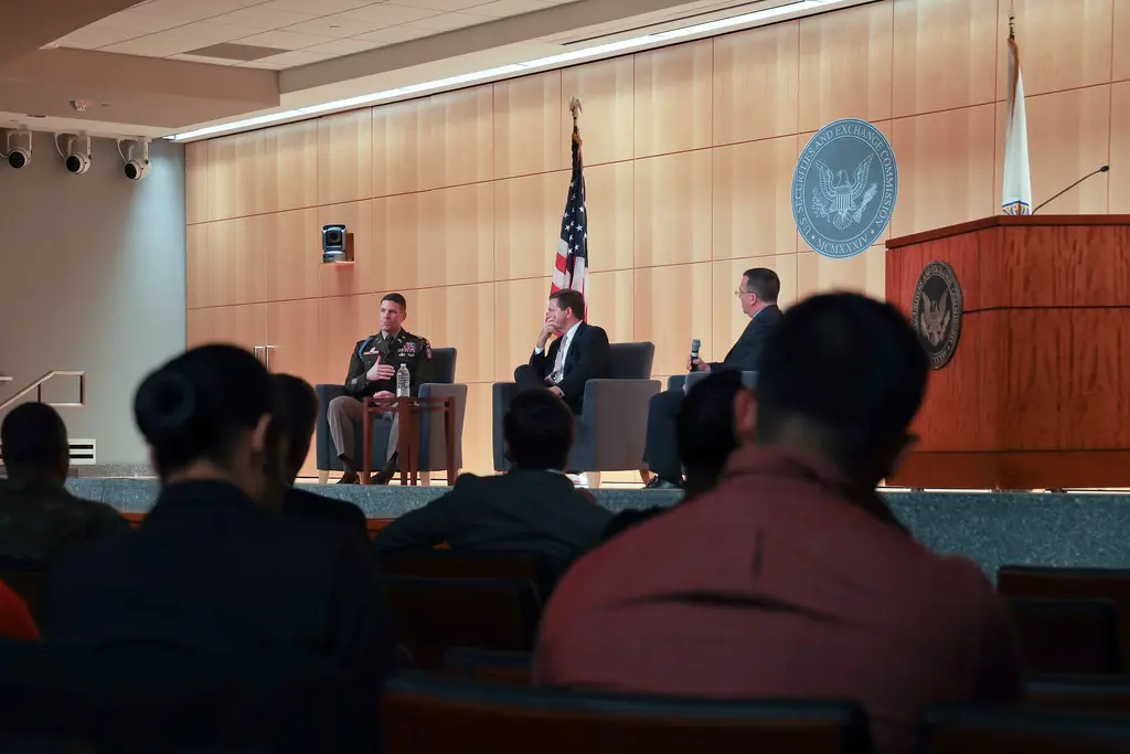 Ein Panel von Sprechern vor einer Holzwand mit dem Siegel der U.S. Securities and Exchange Commission.