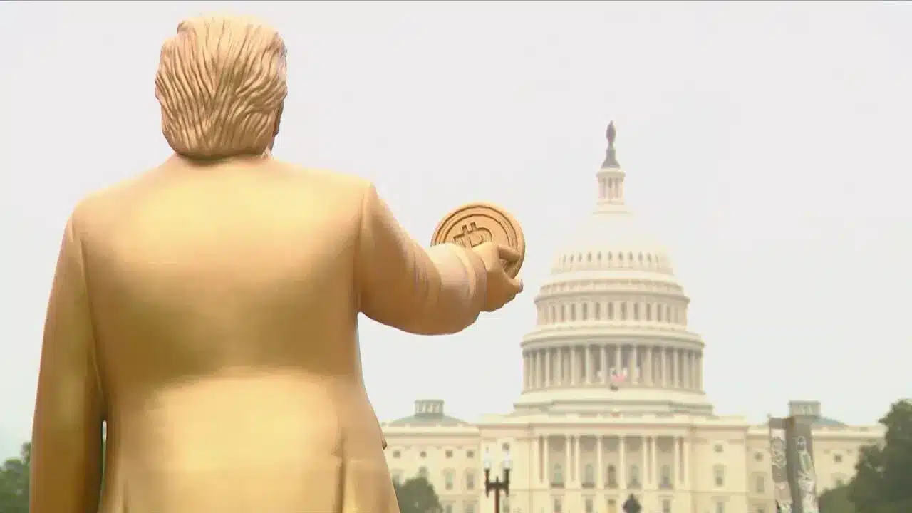 Colocan una estatua dorada de Trump sosteniendo un Bitcoin frente al Capitolio de Estados Unidos