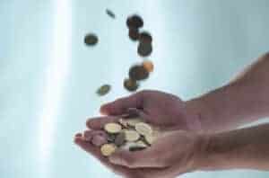 Close up of hands catching pile of coins