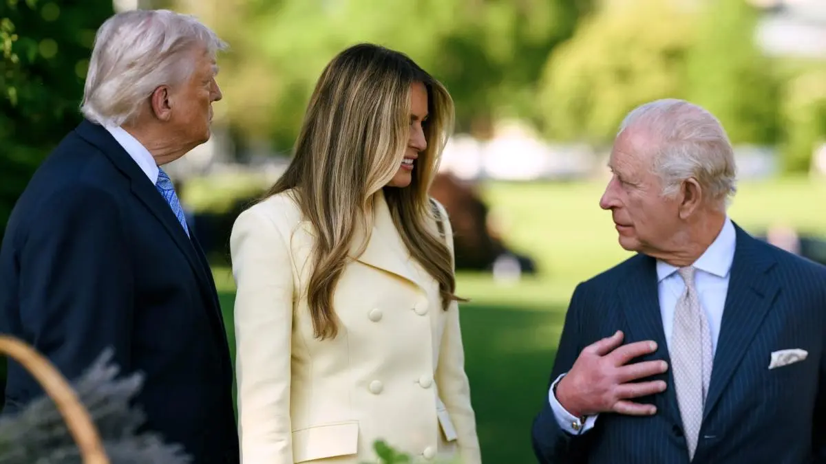 Donald Trump, Melania Trump, and King Charles III conversing outdoors.