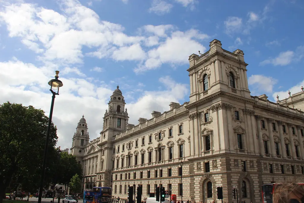 The exterior of the HM Revenue & Customs building in the UK under a blue sky with clouds.